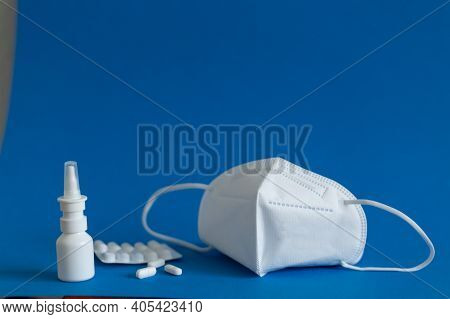 Ffp3 Mask, Nasal Drops, Thermometer, Tablets, Various Medicines Lie On The Table, Top View, On A Blu