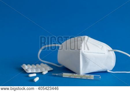 Ffp3 Mask, Nasal Drops, Thermometer, Tablets, Various Medicines Lie On The Table, Top View, On A Blu