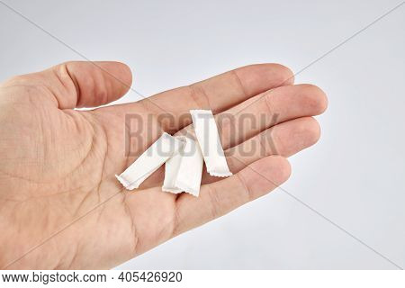 Snus Nicotine Product At Hand Palm. Copy Space. Stack Of White Small Bags In The Hand.