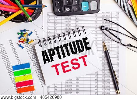 On The Table There Are Reports, A Calculator, Colored Pencils And Stickers, A Pen And A Notebook Wit