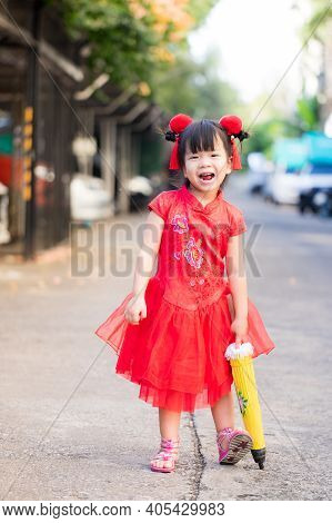 Beautiful Child Wearing Red Chinese Clothes Takes Walk On Holiday Of Traditional Chinese New Year. B