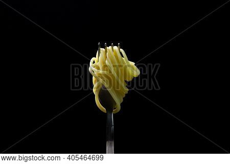 Spaghetti On A Black Background. Boiled Spaghetti On A Fork. Isolated Spaghetti