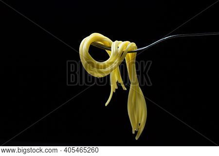 Spaghetti On A Black Background. Boiled Spaghetti On A Fork. Isolated Spaghetti. Stuck Together Spag