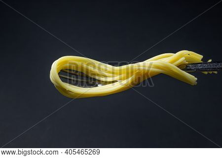 Spaghetti On A Black Background. Boiled Spaghetti On A Fork. Isolated Spaghetti. Stuck Together Spag