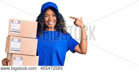Young african american woman holding delivery package pointing finger to one self smiling happy and proud 