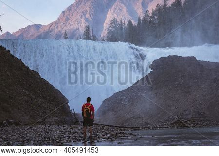 Rear view of man looking at waterfall