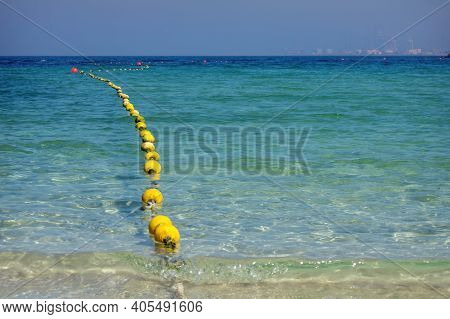 Seascape With Floating Buoys And Rope Dividing Area On Beach. Clear Blue Water And Sandy Beach On Se