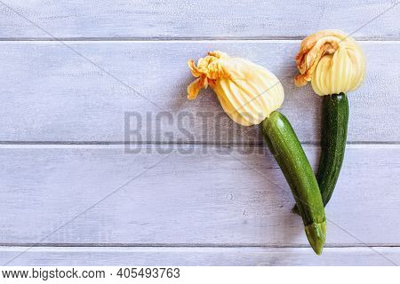 Flatlay Of Baby Courgette Or Zucchini Squash With Blossoms Over A Rustic Blue Wood Table.  Shot From