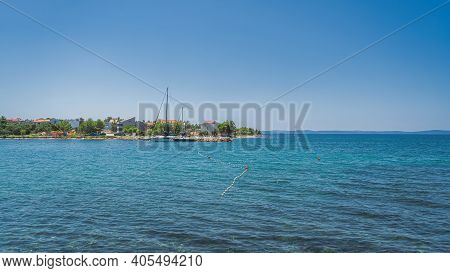 People Relaxing In Clear Waters Of Zaton Bay With Rocky Coastline. Families Having Fun In Turquoise 