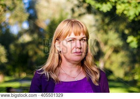 Elegant Mature Woman Outdoors On Blurred Green Nature Background With Bokeh.
Portrait Of Beautiful P