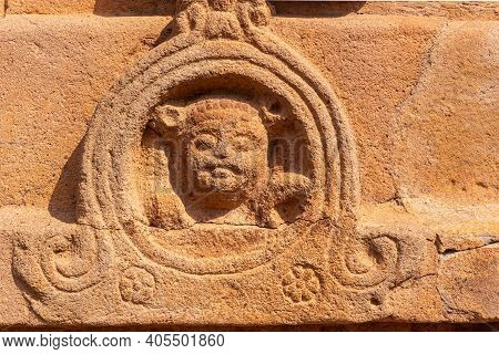 Aihole, Karnataka, India - November 7, 2013: Durga Gudi Or Temple. Closeup Of Damaged Red Stone Scul