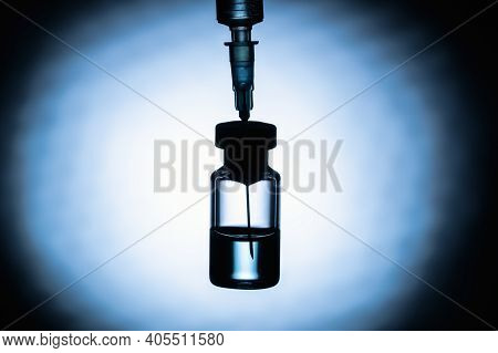 Blurred. Medical Syringe With The Coronavirus Vaccine On A Red And Black Background On The Lumen, Si