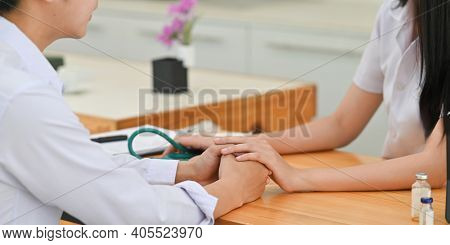 Cropped Image Of Medical Students Comforting Together While Sitting At Wooden Working Desk Over Comf