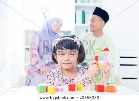 Casa in legno della costruzione bambino musulmano. Sud-est asiatica ragazza gioco woodblock casa a casa.