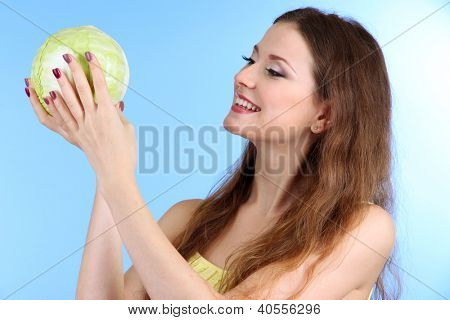 Beautiful woman with cabbage on blue background