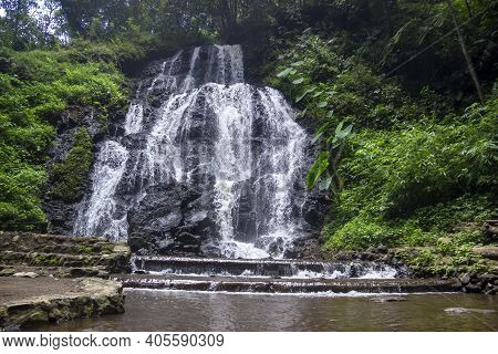 Watu Lumpang Waterfall Is A Tourist Destination In East Java. Low And Wide Waterfall Between Cliffs 