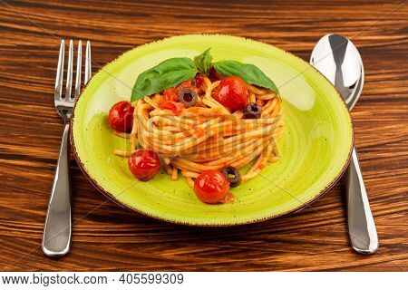 Pasta Spaghetti Napoli Or Napolitana On Green Plate With Fork And Spoon On Brown Background. Italian