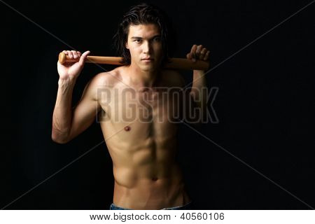 Imagen de hombre semidesnudo con bate mirando a cámara