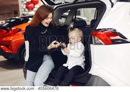 Elegant Woman With Little Daughter In A Car Salon