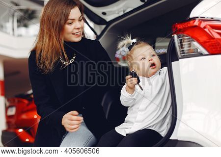 Elegant Woman With Little Daughter In A Car Salon