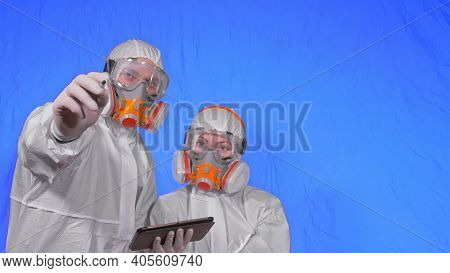 Scientist Virologist In Respirator Makes Write In An Tablet Computer With Stylus. Man And Woman Wear