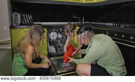 Mother And Father Teaching Daughter Learning To Use Dishwasher. Mistress Girl Children Loading Putti