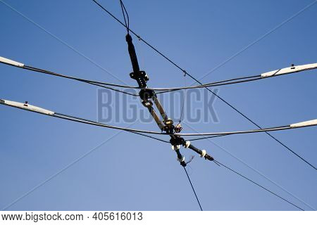 Overhead Electric Transmission Lines Against Blue Sky Background. Industrial Electric Cable Lines Pa