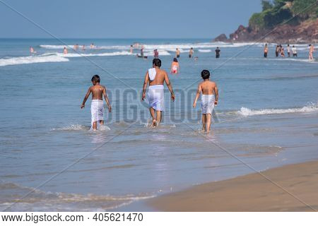 Indian Man And Kids, All Wearing Traditional Swimming Garments, Enjoy The Sea In Varkala, Kerala. Fa