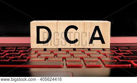 A Wooden Bar With A Dca Word Written On It On The Illuminated Laptop Keyboard