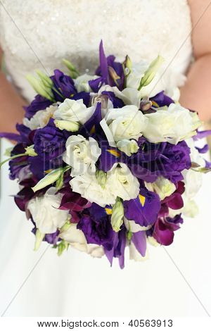 Noiva segurando o Bouquet com flores brancas de rosas e roxos