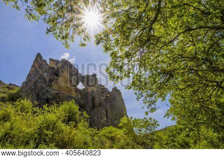 Rocky Mountain With A Hole In The Middle Seen Through Some Trees, In The Peregrina Gorge En El Parqu