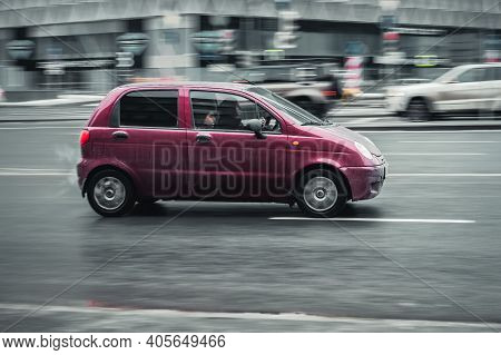 Moscow, Russia - January 29, 2021: Fast Moving Magenta Car On The City Road. Compact City Hatchback 