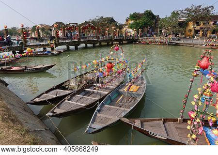 Hoi An, Vietnam, January 29, 2021: Boats Decorated With Lanterns Anchored In The Thu Bon River Next 