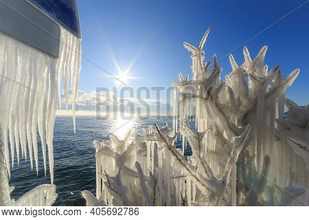 Icicles On Brunches Of Trees And Billboard On The Coast Of Baikal Lake