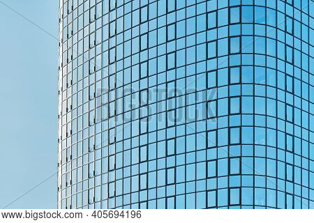 Stylish Skyscraper With Glass Facade Against Clear Blue Sky