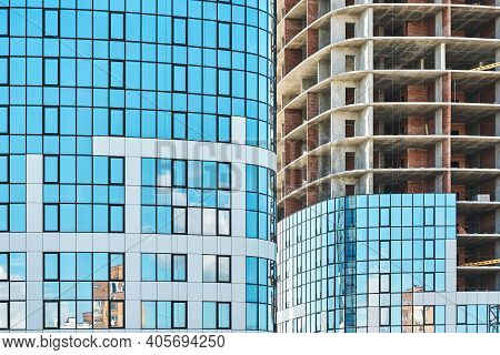 Skyscrapers With Blue Glass And Carcass At Construction Site