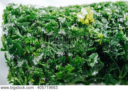 Close Up Image Of Frozen Parsley Green Briquette Covered With Tiny Ice Crystals.