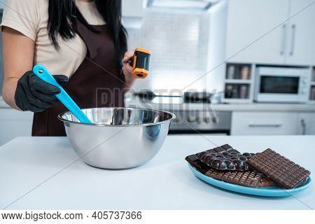 Closeup Of Female Measuring Temperature Of Melted Chocolate With Pyrometer