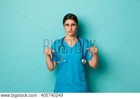 Coronavirus, Pandemic And Social Distancing Concept. Image Of Reluctant And Gloomy Female Nurse In S