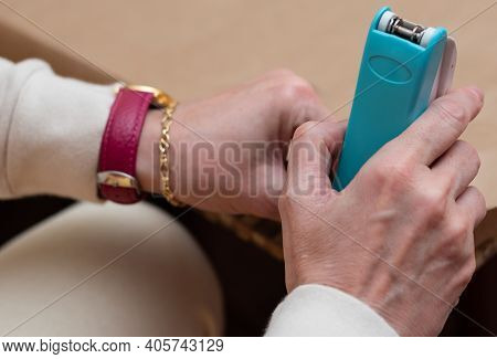 Close Up Of A Woman's Hands Making Handicrafts With A Blue Stapler