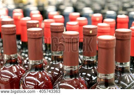 Wine Bottles In A Row, Selective Focus. Liquor Store, Red And Rose Wine Production Concept