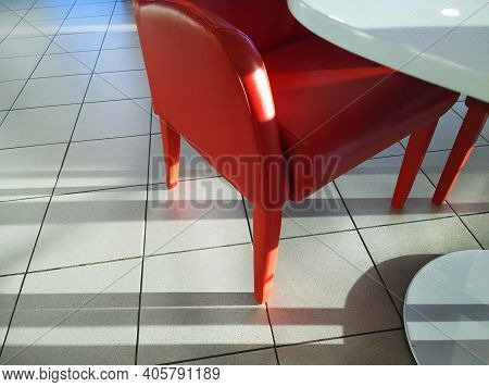 Details Of Red Eco Leather Armchair And White Table. Close-up. Legs Of Modern Elite Chare On The Flo