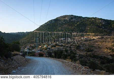 Small remote village Gey in mountains of Mediterranean region in Turkey, View from Lycian way hiking trail, Evening last light, gravel road