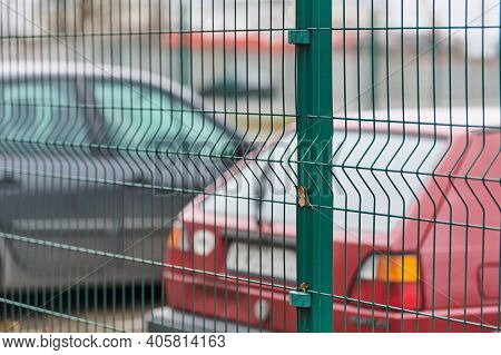 Fenced Car Parking Lot With Security. Guarded Territory Of Paid Hourly Parking. Blurred Cars Backgro