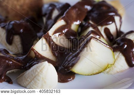 Banana Pear Dessert On White Plate Poured With Chocolate. Vegetarian Salad.