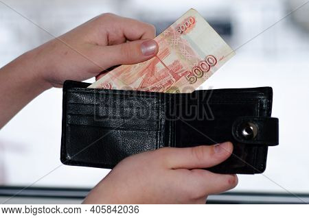 Young Man Takes Out  5000-ruble Banknote From  Black Wallet. Russian Cash. Finance.
