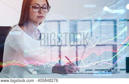 Business Woman Writing Down Some Figures Based On Stock Market Rates To Predict Behaviour Of Forex C