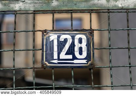 Number 128, The Number Of Houses, Apartments, Streets. The White Number On A Blue Metal Plate, House