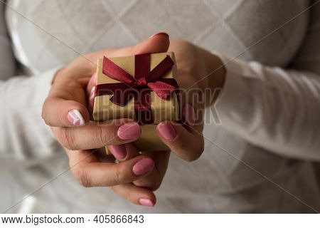 Woman Hands Holding A Small Present Box With Red Ribbon Over. Valentine Gift Box. Close Up Shot Of F