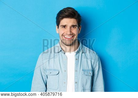 Close-up Of Young Man Feeling Awkward, Smile And Cringe From Uncomfortable Situation, Standing Over 